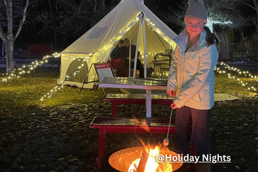 Tent with a girl making s'mores