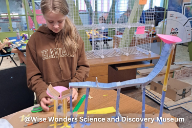 Girl working on a paper ball run challenge