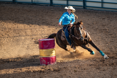 Woman riding a horse during barrel racing